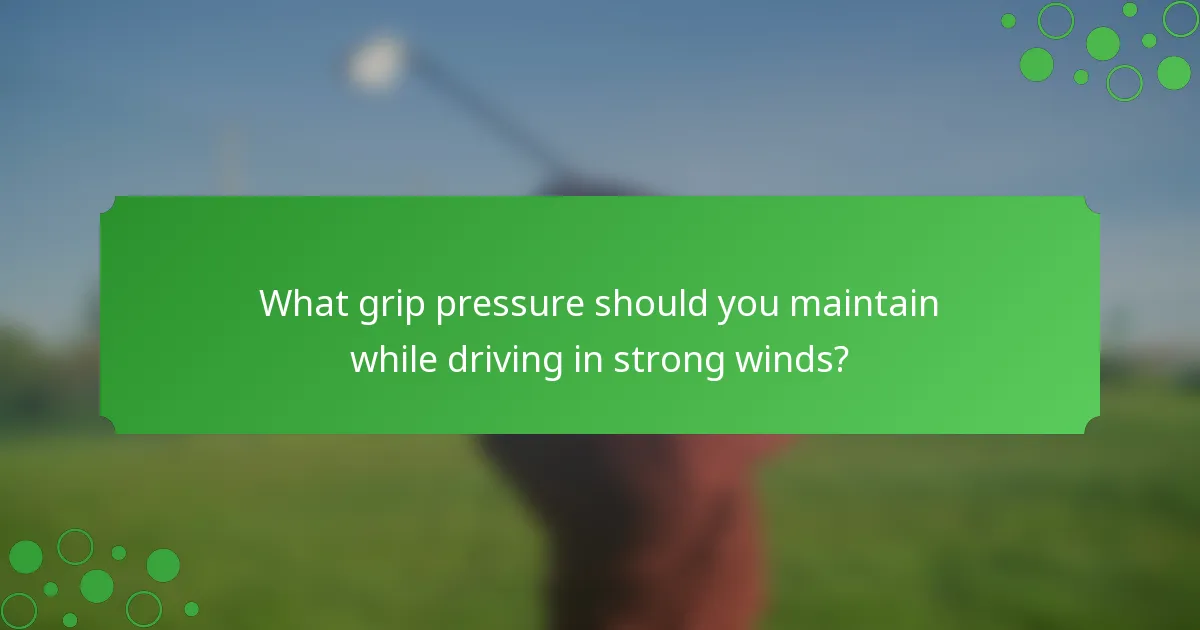 What grip pressure should you maintain while driving in strong winds?